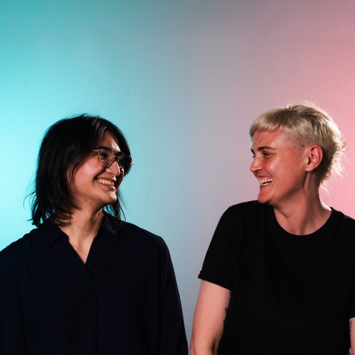 Two people are turned towards each other, laughing.