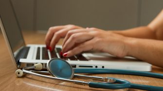 Stephoscope and laptop computer with hands typing
