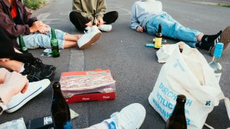 Group of young people drinking and smoking in the street