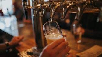 Person pouring beer into a glass from a beer tap