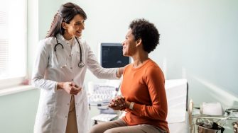Doctor reassuring a patient during a consult stock image
