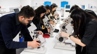 Group of students looking down microscopes