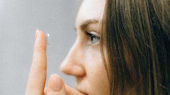 Young woman preparing to put contact lens on