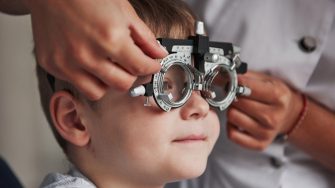 Close up portrait of child in special glasses in ophthalmologist cabinet.
