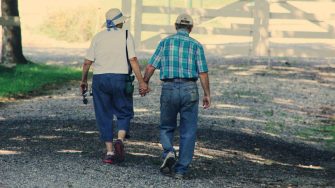 Older couple walking away holding hands