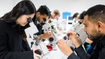Students in a lab working on microscopes