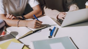 Male Asian student making new project with his friend at table
