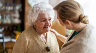 Health visitor talking to a senior woman during home visit  