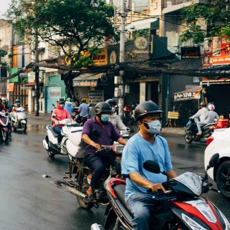 Scooter riders on city street in Vietnam