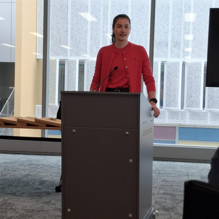 Dyone Bettege speaks at a podium