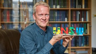 Professor Pasi Sahlberg with Lego blocks that spell out UNSW