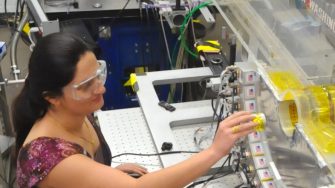 Female engineer inserting yellow cylinder into lab machine