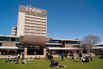 Sydney, Australia - August 17, 2012: Students and graduates converge on a lawn before the University of New South Wales (UNSW) library on a clear winter morning