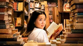 Young woman in a bookshop surrounded by books