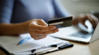 Woman using credit card and laptop to pay bills