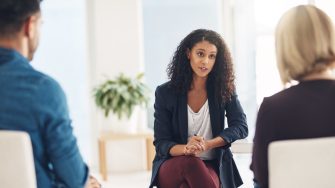 Shot of a young therapist speaking to a couple during a counseling session