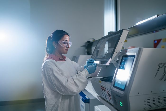 Researcher in Grainne Moran Research Labs using a KingFisher instrument for molecular extraction