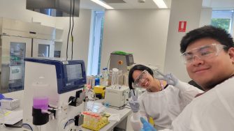 Two trainees in RPF lab learning how to use filtration systems