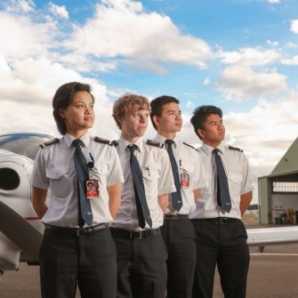 Four students standing in front of an airport