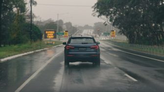 Black car on a wet road during daytime