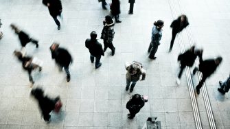 Overhead view of people walking on grey concrete tiles