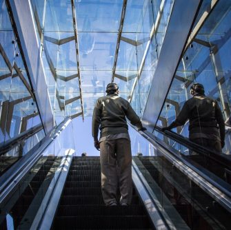 Man standing on an escalator during daytime