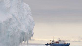 Iceberg in foreground with ship in background