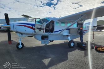 Small plane with a person loading equipment into the  back