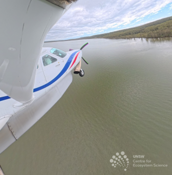 Side of airplane with brown water beneath