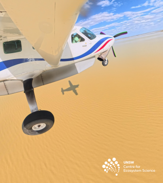 Light airplane in flight over brown water