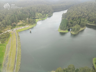 Aerial view of large waterbody with green landscape around