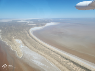 Aerial view of landbank in centre, white shorelines and brown water