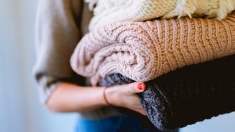 Young woman holding folded laundry