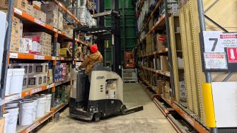 A picture of Cliffy operating a forklift in the warehouse called the Green House.