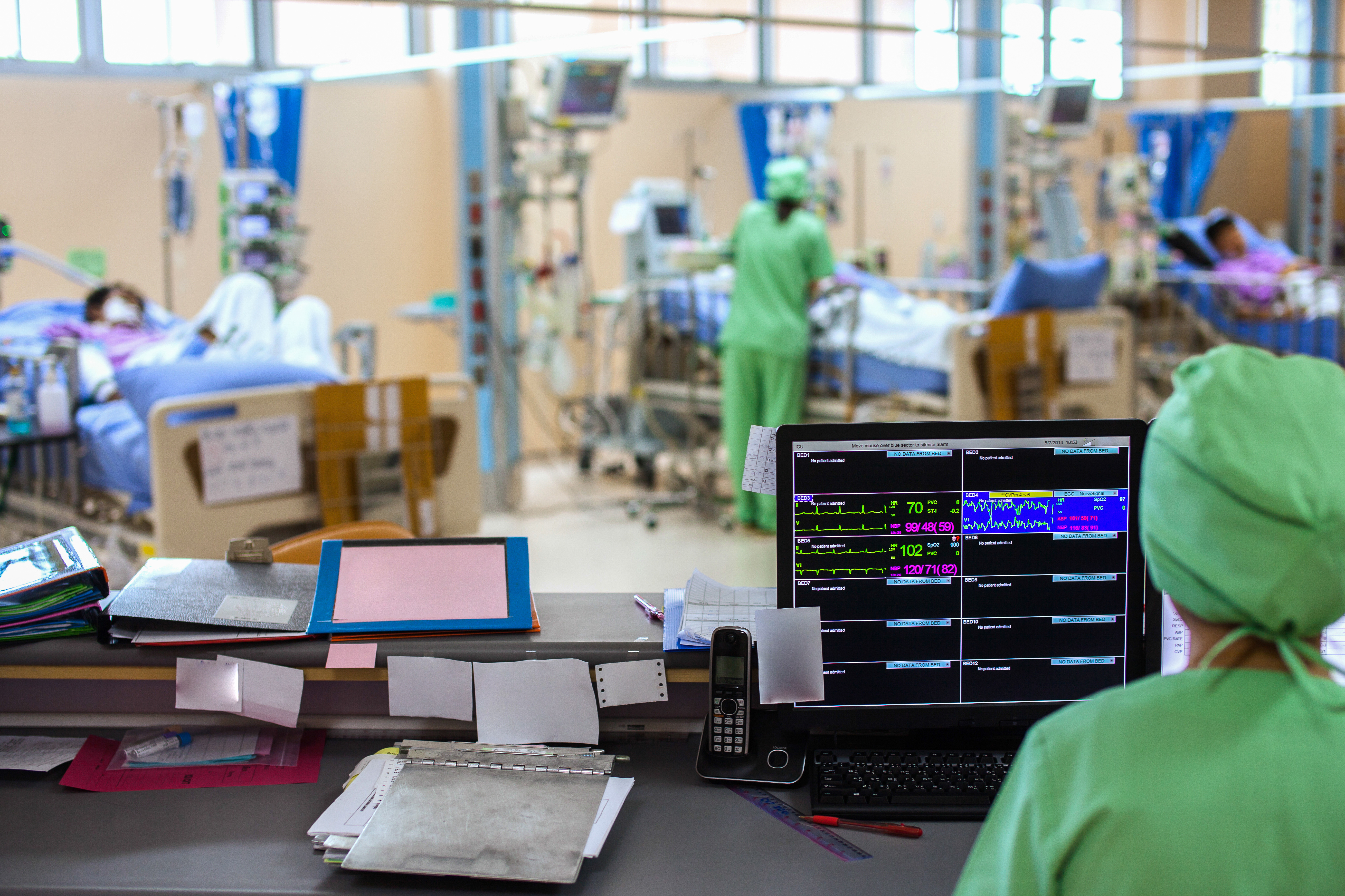 Several doctors and patients in a busy ICU