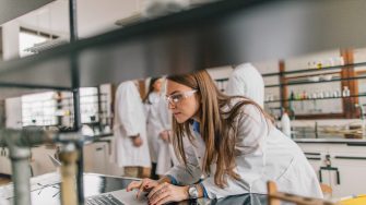 Female chemist using computer in chemical laboratory
