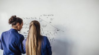 Girls doing maths on whiteboard