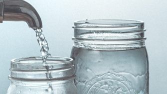 Clear glass jars under a tap