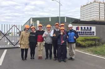 students in front of factory