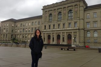 student in front of building