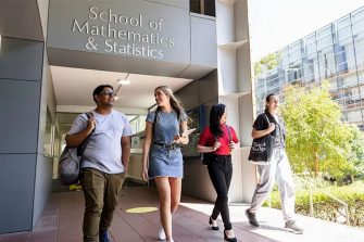 Four students walk and talk outside the UNSW School of Mathematics & Statistics