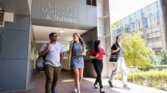 Four students walk and talk outside the UNSW School of Mathematics & Statistics