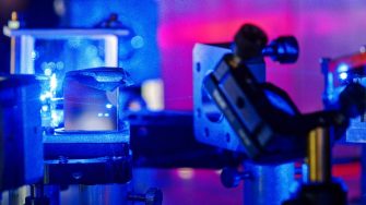 Blue laser on optical table in a quantum optics lab.