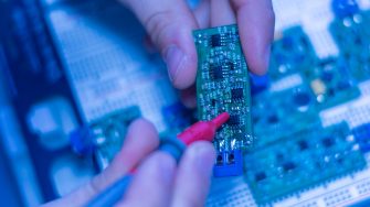 engineer hold circuit or silicon chip in his workplace