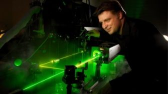 Clemens Ulrich standing infront of a green laser