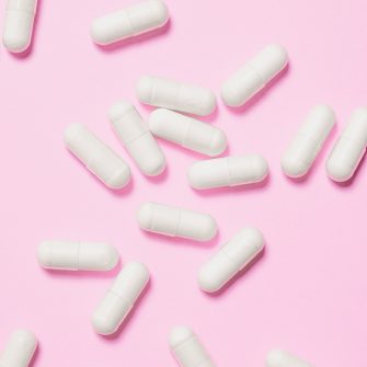 White pills on pink background