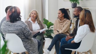 Counseling, group and psychology discussion with group of diversity people in therapy for depression, stress and anxiety. Men and women healing during psychologist meeting talking about mental health