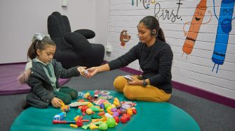 Image of woman handing toy to small child