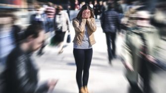 Woman standing in crowd covering eyes