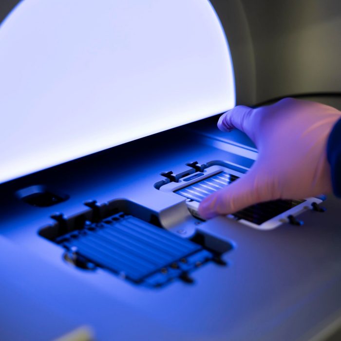 Lab technician putting a flowcell in a sequencer